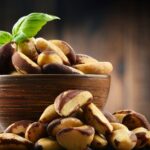 Organic Brazil nuts in a bowl next to loose nuts