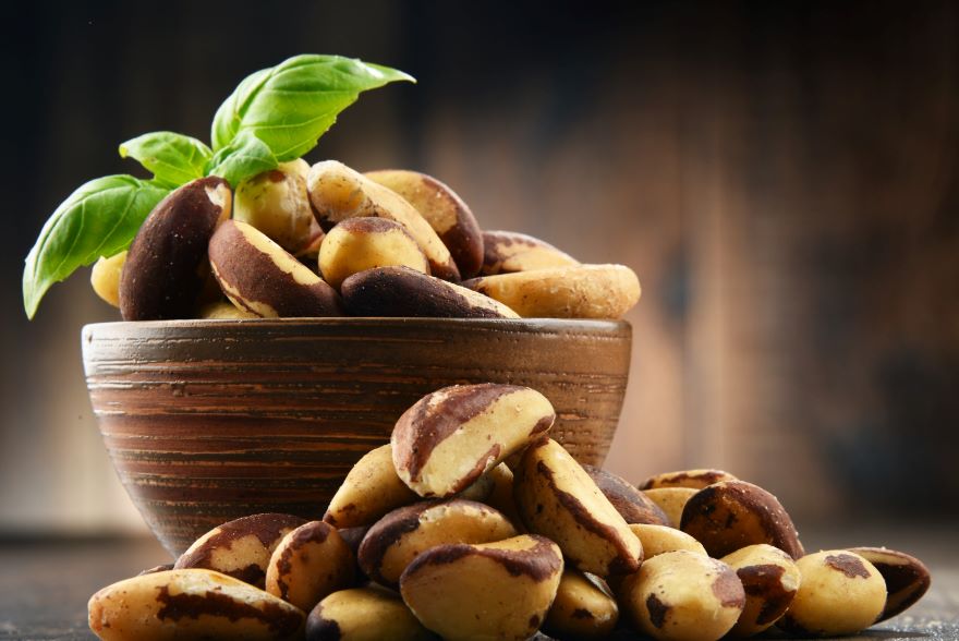 Organic Brazil nuts in a bowl next to loose nuts