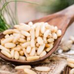 Raw pine nuts on a spoon