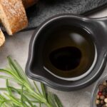 Cars in balsamic vinegar in a jug next to bread