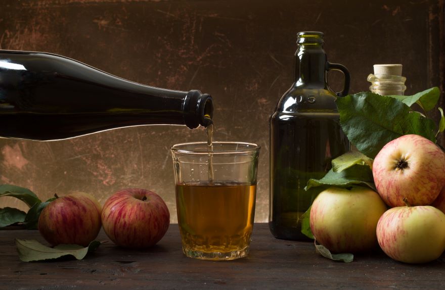 Is cider vinegar the same as apple cider vinegar? with two bottles and a glass