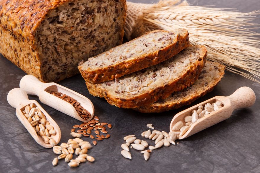 Superfood bread sliced next to different grains
