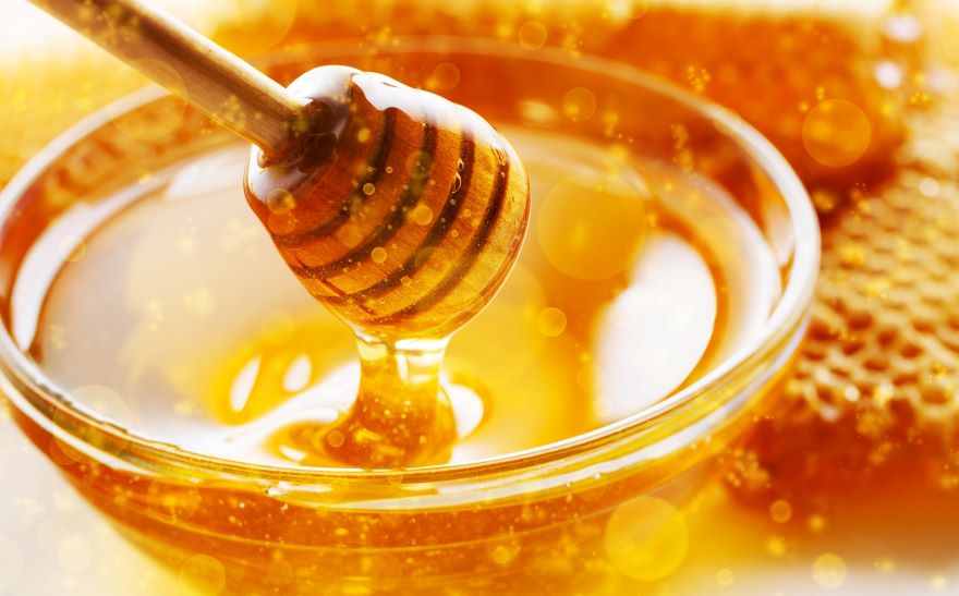 Superfood honey in a bowl with stirrer