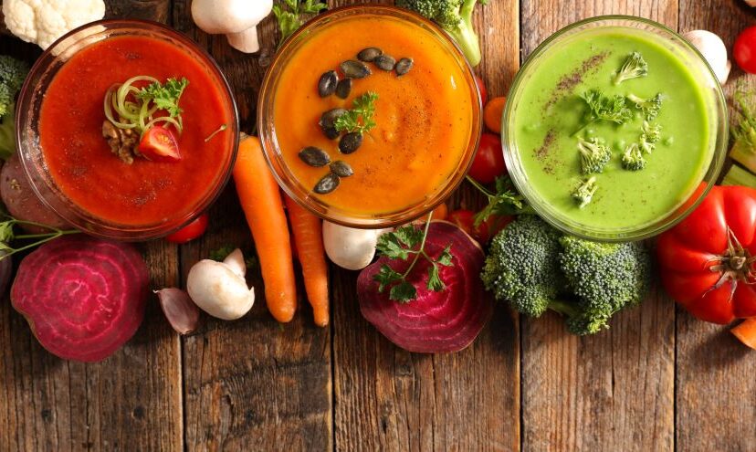 Superfood soup in three bowls next to vegetables