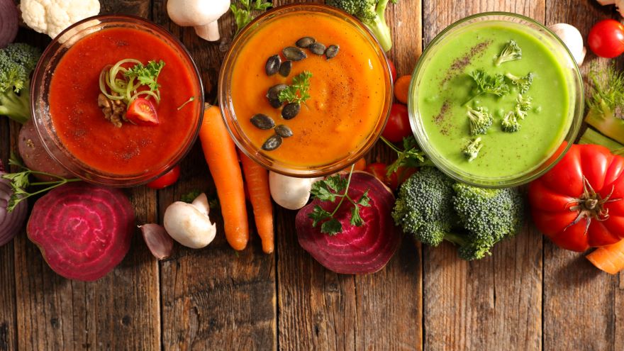 Superfood soup in three bowls next to vegetables