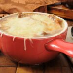 Gluten-free French onion soup in a red bowl