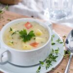 Dairy-free potato soup in bowl with herbs on