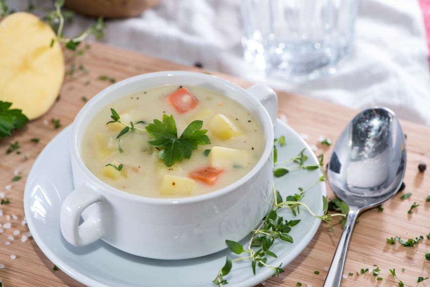 Dairy-free potato soup in bowl with herbs on