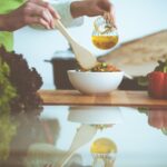 Eat to live retreat with hands serving from a bowl of vegetables