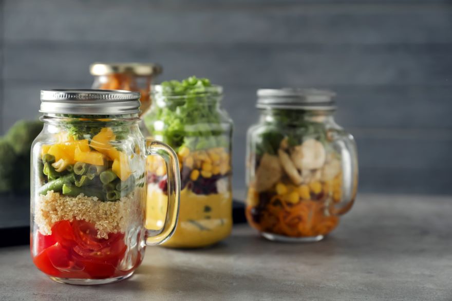 Freezer-safe containers full of vegetable salads