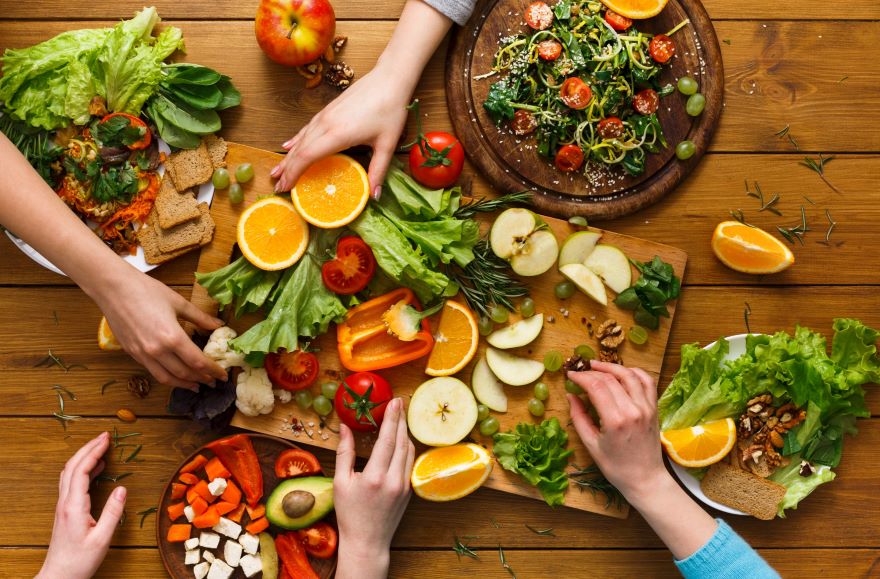Nutritarian recipes with hands taking fruit and veg from a platter