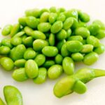 Costco edamame with shelled edamame beans next to pods