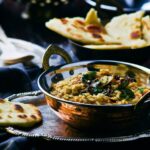 Madras lentils in a bowl with popadoms