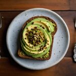 Avocado toast on turmeric flaxseed superfood bread on a white plate