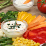 Kefir ranch dip with fresh veggie sticks on a plate with dip in the middle