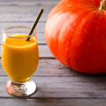 Organic pumpkin spice smoothie next to a pumpkin