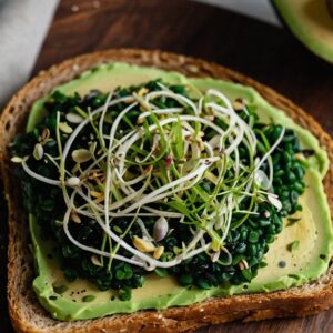 Spirulina-infused avocado toast with hemp seeds on a board