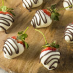 White chocolate-covered strawberries on a wooden board