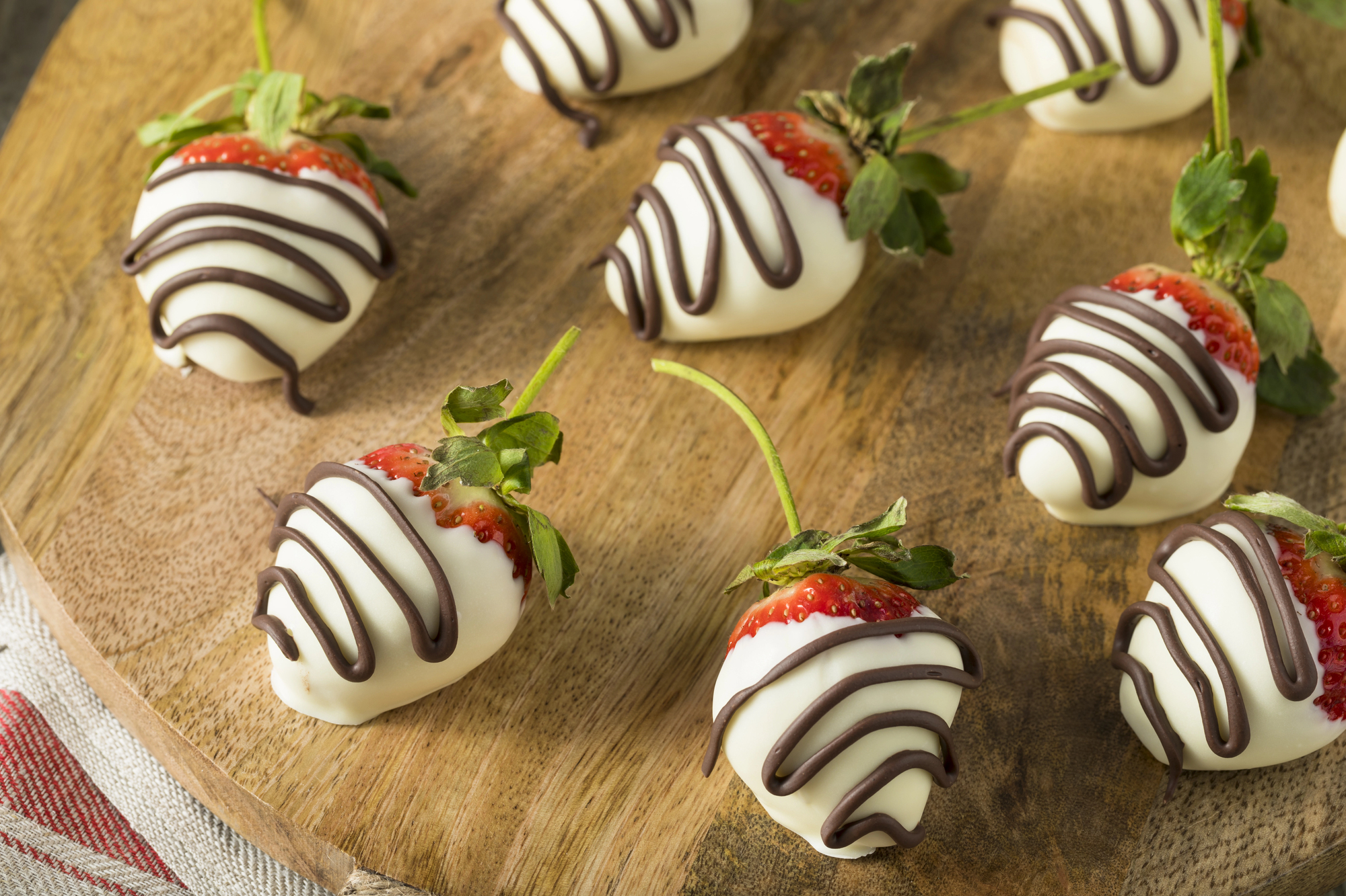 White chocolate-covered strawberries on a wooden board