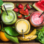 Smoothies with three smoothies with fruit surrounding them
