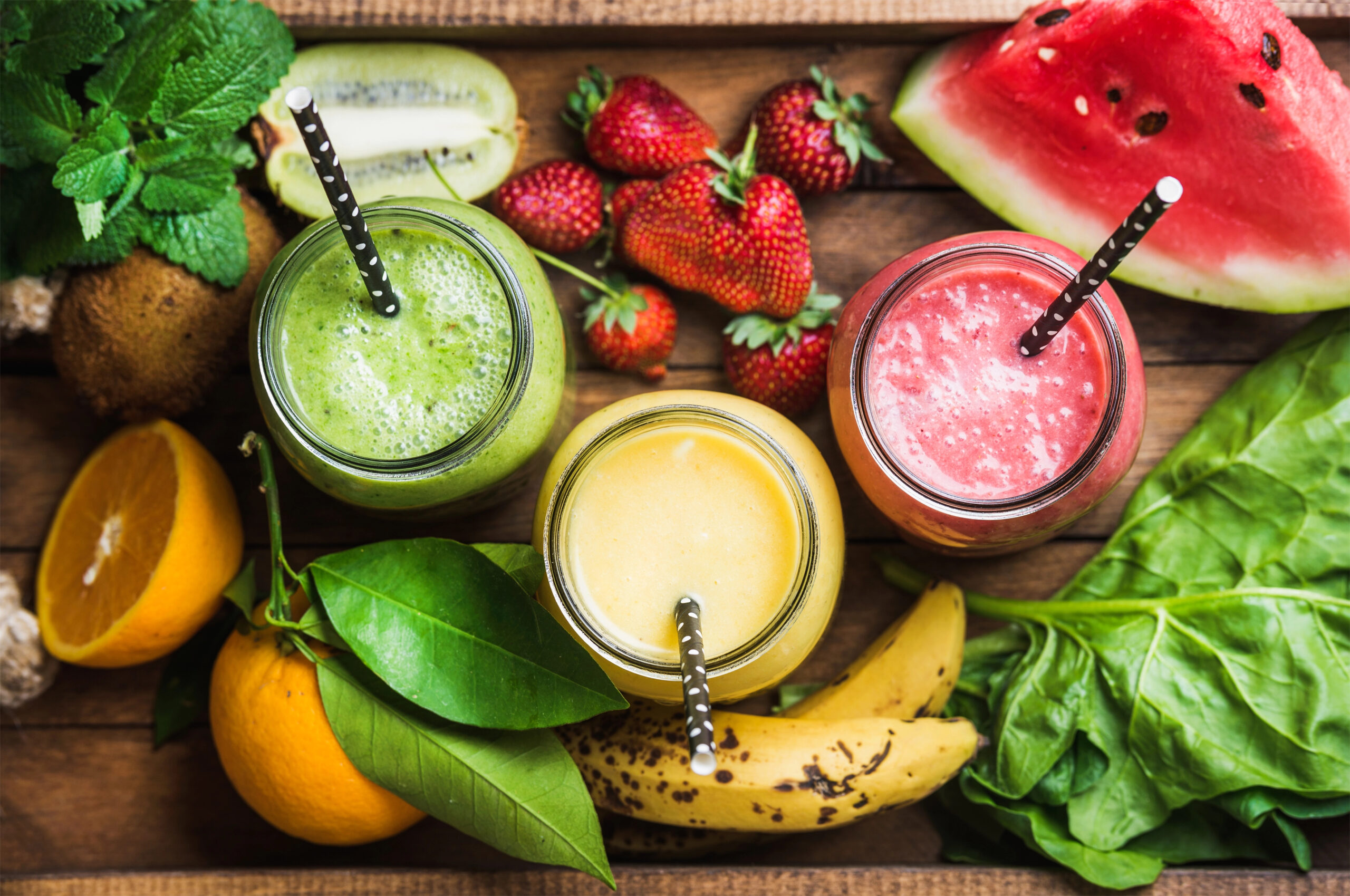 Smoothies with three smoothies with fruit surrounding them